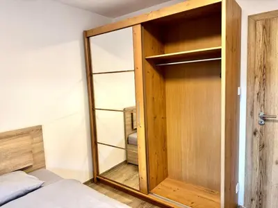 a bedroom with a wooden closet with a mirror at Comfortable apartmant in Prague in Prague