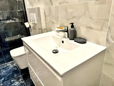 a bathroom with a white sink with a bottle on it at Comfortable apartmant in Prague in Prague