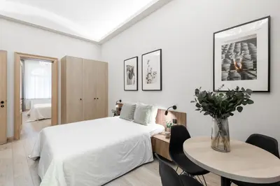 a bedroom with a white bed and a table and chairs at Premium City Center Apartment Prague - 4 Guests in Prague
