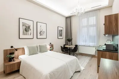 a white bedroom with a bed and a table at Premium City Center Apartment Prague - 4 Guests in Prague
