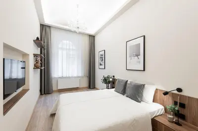 a white bedroom with a large bed and a tv at Premium City Center Apartment Prague - 4 Guests in Prague