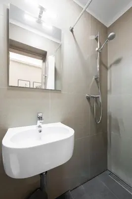 a bathroom with a white sink and a shower at Premium City Center Apartment Prague - 4 Guests in Prague