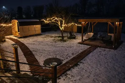 a snow covered yard with a gazebo at night at Studio Big Win Mělník in Pšovka