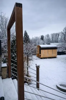 a snow covered yard with a wooden fence and a barn at Studio Big Win Mělník in Pšovka