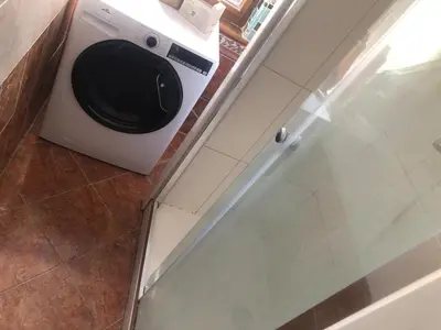 a washing machine in a kitchen with a glass door at Central cozy rooms Soukenická S33 in Prague