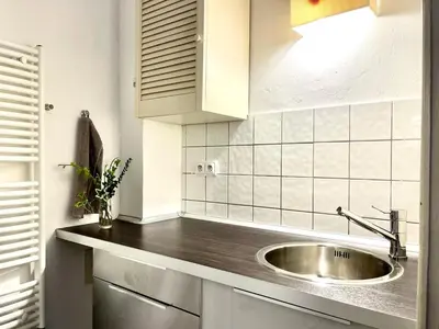 a kitchen with a stainless steel sink and white tiles at Prague apartment 3 minutes from historical town in Prague