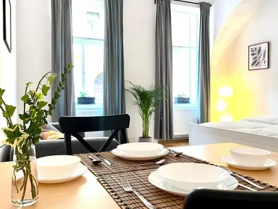 a dining room table with white dishes on it at Prague apartment 3 minutes from historical town in Prague