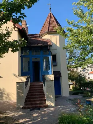 a small house with a blue door and stairs at Art nouveau villa with garden close to center in Prague