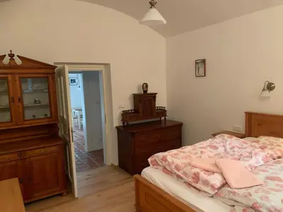 a bedroom with a bed and a dresser and a mirror at Art nouveau villa with garden close to center in Prague