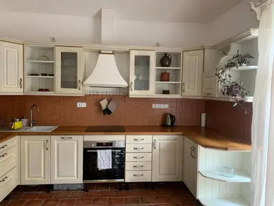 a kitchen with white cabinets and a stove top oven at Art nouveau villa with garden close to center in Prague