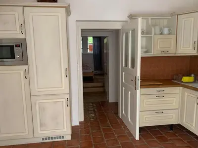 a kitchen with white cabinets and a tile floor at Art nouveau villa with garden close to center in Prague
