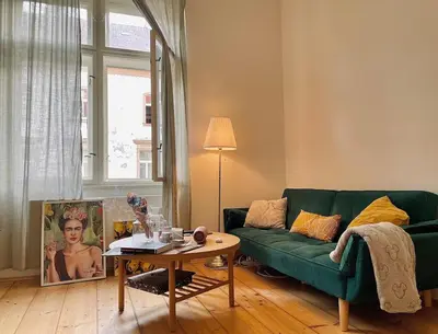 a living room with a green couch and a table at Charming 1BDR nest with balcony in Prague