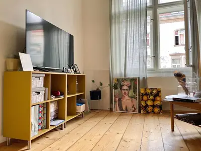 a living room with a yellow cabinet and a television at Charming 1BDR nest with balcony in Prague