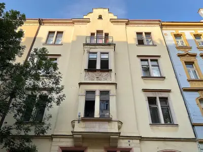 a tall white building with windows and a balcony at Charming 1BDR nest with balcony in Prague