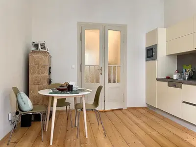 a kitchen with a table and chairs in a room at Charming 1BDR nest with balcony in Prague