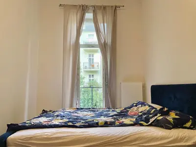 a bed in a room with a window at Charming 1BDR nest with balcony in Prague