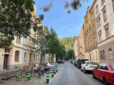 a cobblestone street with parked cars and parked bikes at Charming 1BDR nest with balcony in Prague