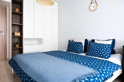 a bedroom with a blue bed with blue pillows at Apartment near PVA Expo Prague & Concerts in Prague