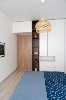 a bedroom with a blue bed and a chandelier at Apartment near PVA Expo Prague & Concerts in Prague