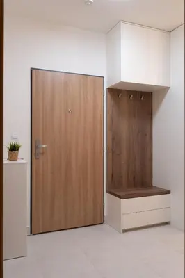 a wooden door in a white room with a shelf at Apartment near PVA Expo Prague & Concerts in Prague