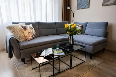 a living room with a couch and a table with flowers at Apartment near PVA Expo Prague & Concerts in Prague