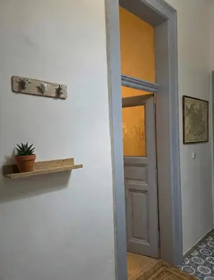 an open door with a shelf and a plant on a wall at Anhouse in Prague