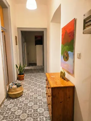 a hallway with a wooden table and a tile floor at Anhouse in Prague