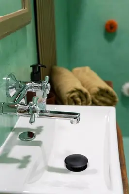 a white bathroom sink with a soap dispenser on it at 2 bedroom apartment in New Town close to river in Prague