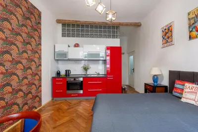 a kitchen with red cabinets and a red stove at 2 bedroom apartment in New Town close to river in Prague