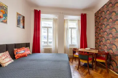 a bedroom with a bed and a table and red curtains at 2 bedroom apartment in New Town close to river in Prague