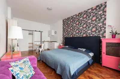 a bedroom with a bed and a pink couch at Cozy Central apartment by Charles Square in Prague