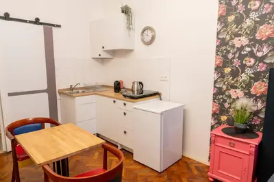 a small kitchen with a table and a refrigerator at Cozy Central apartment by Charles Square in Prague