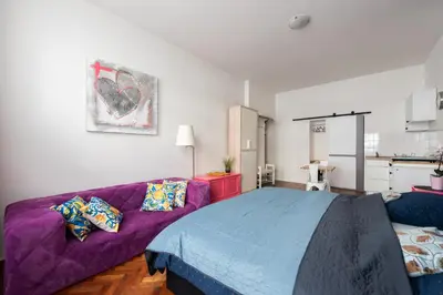 a living room with a purple bed and a purple couch at Cozy Central apartment by Charles Square in Prague