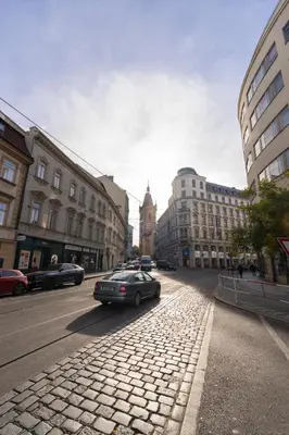 a car driving down a city street with buildings at Cozy Central apartment by Charles Square in Prague