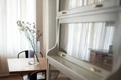 a vase of flowers sitting on a table next to a window at Prime Location Modern flat in Prague centre in Prague