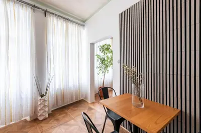 a dining room with a table and chairs and a window at Prime Location Modern flat in Prague centre in Prague