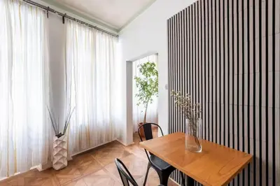 a dining room with a table and chairs and a window at Prime Location Modern flat in Prague centre in Prague