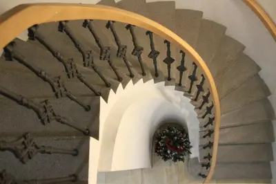 a spiral staircase with a christmasreath on it at Aparthotel Tycho de Brahe in Prague