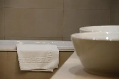 a white towel on a counter next to a bath tub at Aparthotel Tycho de Brahe in Prague