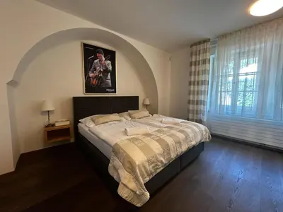 a bedroom with a large bed and a window at Aparthotel Tycho de Brahe in Prague