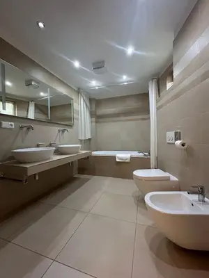 a bathroom with two sinks and a toilet and a tub at Aparthotel Tycho de Brahe in Prague