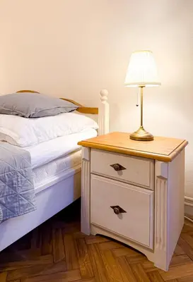 a bed and a nightstand with a lamp on it at Goldy River 3 BDR & 1 BTH Residence XXL 120m2 in Prague