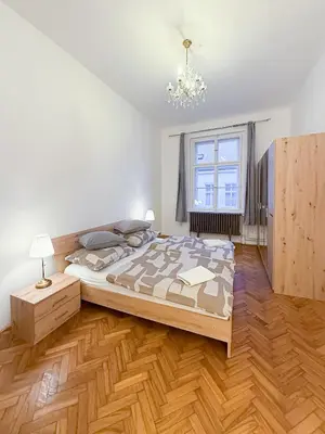 a bedroom with a large bed and a wooden floor at Goldy River 3 BDR & 1 BTH Residence XXL 120m2 in Prague