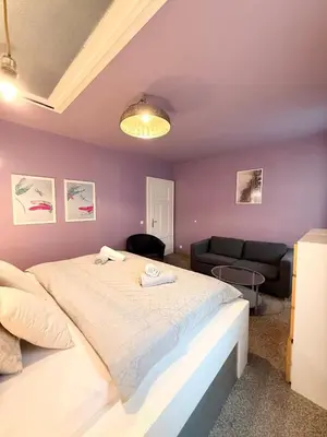 a bedroom with a large bed and a couch at Purple Dragon 3BDR apartment in Prague