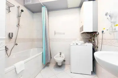 a bathroom with a tub and a toilet and a sink at Purple Dragon 3BDR apartment in Prague