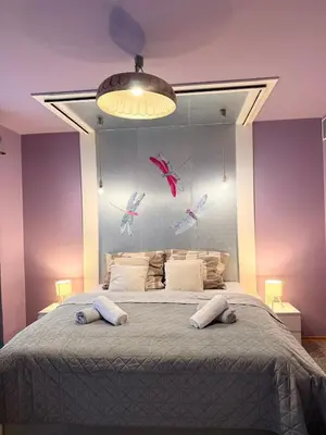 a bedroom with a large bed with birds on the wall at Purple Dragon 3BDR apartment in Prague