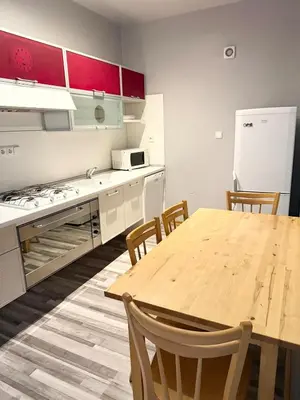 a kitchen with a wooden table and a refrigerator at Purple Dragon 3BDR apartment in Prague