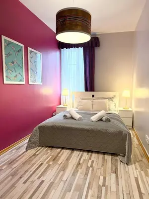 a bedroom with a large bed with a purple wall at Purple Dragon 3BDR apartment in Prague
