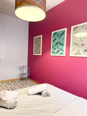 a bedroom with a pink wall and a bed at Purple Dragon 3BDR apartment in Prague