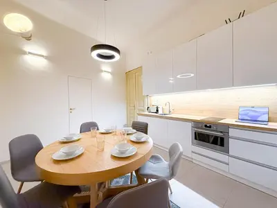 a kitchen with a wooden table and chairs in a room at Picasso Residence XXL 100m2 in Prague